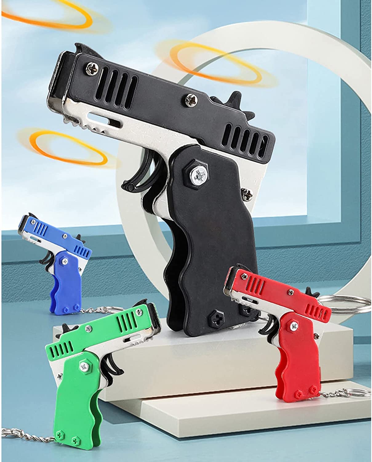 QKUDNGHY Kids Toys Cool Keychain Rubber Band Launcher Toy 4pcs Mini Metal Folding Rubber Launcher Toy with 240 Elastic Rubber Bands for Game Outdoor Activities (4 Colors)