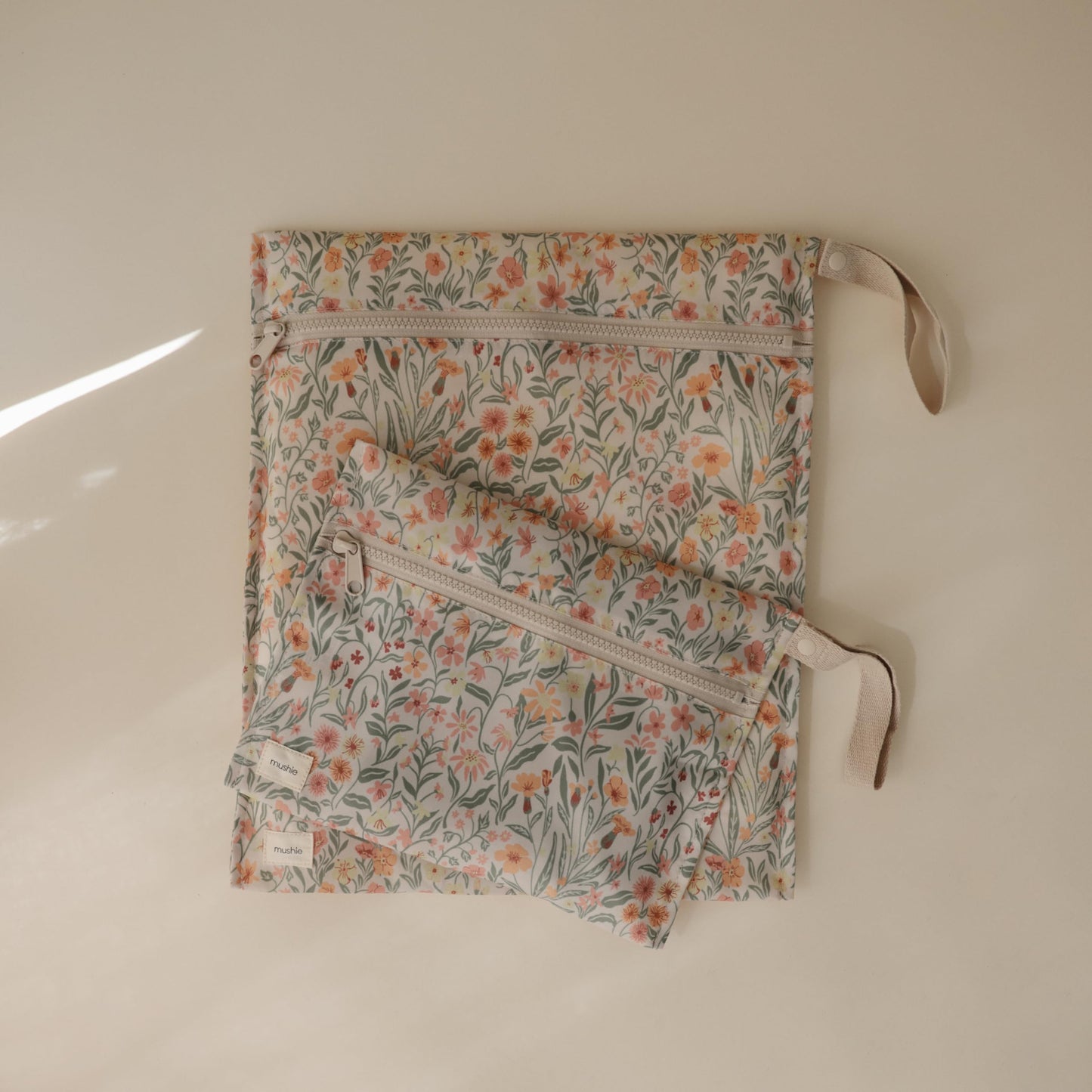 mushie Water Resistant Wet Bags | Large & Small Reusable Storage Bag for Baby Items and Travel | Zippered Pockets with Handle | Machine Washable, Set of 2 (Pastel Blooms)